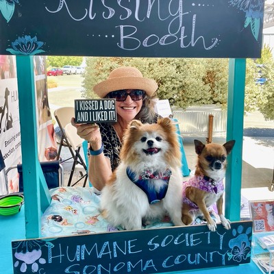 a dog-loving wine club member in the kissing booth to support the humane society of sonoma