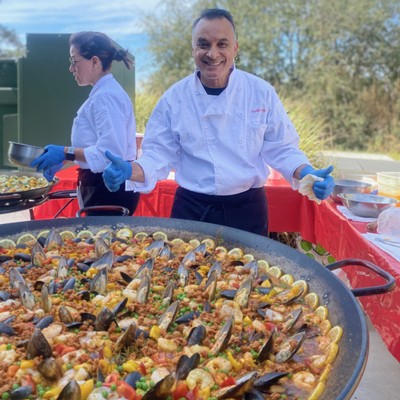 the chefs smiling while making their paella for the paella event